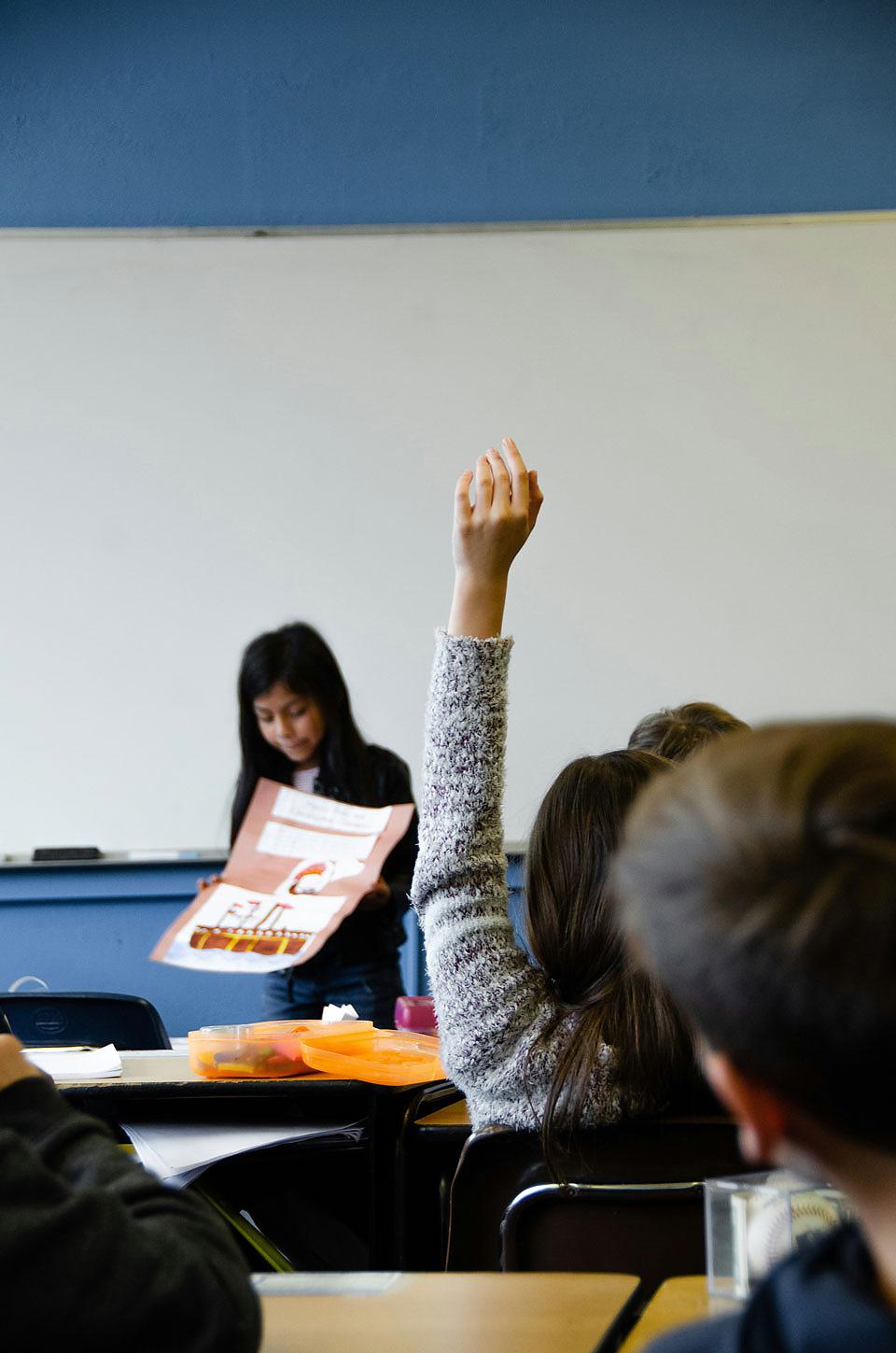 young student presenting a project to her peers